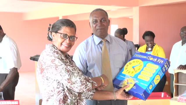 Premier of Nevis and Minister of Education Hon. Vance Amory receives gift of teaching materials from Ms. Sylvia Fahie, representative of donors Brenda and John Scanelli of Virginia at a handing over ceremony at the Department of Education on May 06, 2016